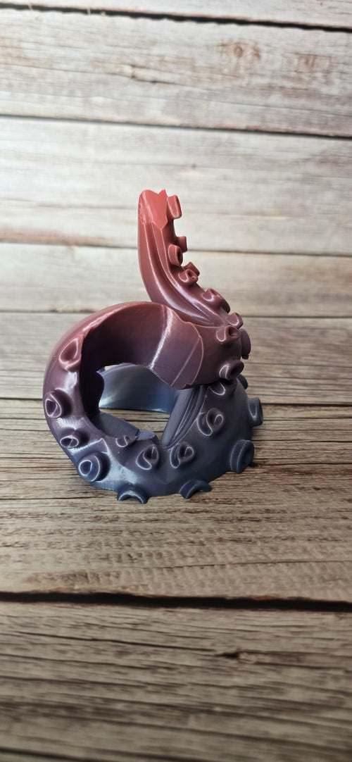 Side view of an empty 3D printed PS5 tentacle controller stand with a curled arm and copper-to-blue colour transition.
